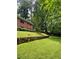 Lush backyard featuring a stone retaining wall and mature trees at 406 S Hillcrest Sw Dr, Marietta, GA 30064