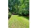 Backyard featuring a stone retaining wall, patio, and mature trees at 406 S Hillcrest Sw Dr, Marietta, GA 30064