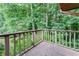 Wooden deck with railing, offering peaceful views of the surrounding mature trees at 4714 Darlene Way, Tucker, GA 30084