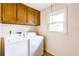 Functional laundry room with white washer and dryer, a window, and upper cabinets at 4714 Darlene Way, Tucker, GA 30084