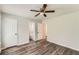 Bedroom showing wood-look floors, ceiling fan, and an open doorway to the en suite bathroom at 7127 Greenway Sw Cv, Covington, GA 30014