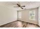 Bright bedroom featuring wood-look flooring, ceiling fan, and two windows for ample natural light at 7127 Greenway Sw Cv, Covington, GA 30014