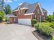 Brick home with a driveway, lush landscaping, and a three-car garage at 1000 Gunter Ct, Alpharetta, GA 30022