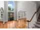 Grand foyer with hardwood floors, soaring windows, an elegant front door, and staircase leading to the upper level at 1000 Gunter Ct, Alpharetta, GA 30022