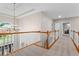 Spacious hallway with wood trim, carpet, and a stunning chandelier with a large arched window overlooking the front entrance at 1000 Gunter Ct, Alpharetta, GA 30022