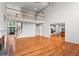 Spacious living room with hardwood floors, brick fireplace, large windows, and access to the staircase and kitchen at 1000 Gunter Ct, Alpharetta, GA 30022