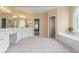 Spacious main bathroom with double vanities, tiled floor, a soaking tub, and separate doorways at 1000 Gunter Ct, Alpharetta, GA 30022