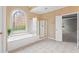 Bright bathroom with a large soaking tub, a glass enclosed shower and gold fixtures at 1000 Gunter Ct, Alpharetta, GA 30022