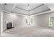 Large main bedroom with tray ceiling, neutral walls, carpet, a fireplace, and abundant natural light at 1000 Gunter Ct, Alpharetta, GA 30022