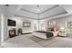 This is a staged main bedroom featuring a trey ceiling, fireplace, and a seating area by the windows at 1000 Gunter Ct, Alpharetta, GA 30022