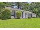 Charming single-story home featuring a well-maintained lawn and complemented by mature trees and greenery at 1234 Wellhouse Walk, Stone Mountain, GA 30088