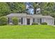 Single-story home with well-kept lawn, trimmed shrubs, and a one-car garage at 1234 Wellhouse Walk, Stone Mountain, GA 30088