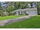 A charming single-story home with an attached garage and a long driveway at 1234 Wellhouse Walk, Stone Mountain, GA 30088