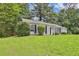 Traditional single-story home with a lush green lawn and mature landscaping at 1234 Wellhouse Walk, Stone Mountain, GA 30088