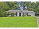Charming single-story home featuring manicured lawn, mature trees, and a one car garage at 1234 Wellhouse Walk, Stone Mountain, GA 30088