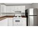 Well-equipped kitchen featuring white appliances, neutral countertops, and efficient lighting at 1234 Wellhouse Walk, Stone Mountain, GA 30088