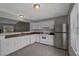Traditional kitchen features white appliances, cabinets, and tile flooring, along with lots of natural light at 1234 Wellhouse Walk, Stone Mountain, GA 30088