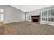 Carpeted living room with brick fireplace and French doors to the backyard at 1234 Wellhouse Walk, Stone Mountain, GA 30088