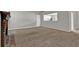 Open-concept carpeted living room shows kitchen access and lots of light at 1234 Wellhouse Walk, Stone Mountain, GA 30088
