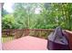 Back deck with wood railing, surrounded by mature trees for privacy at 2540 Ridgehurst Dr, Buford, GA 30518