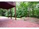 Brick patio with covered deck above looks out on the serene treed backyard at 2540 Ridgehurst Dr, Buford, GA 30518