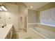 Bright bathroom with a soaking tub, tiled floors, and a doorway to the walk-in closet at 2540 Ridgehurst Dr, Buford, GA 30518