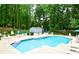 Bright blue community pool surrounded by lush trees and chairs, creating a relaxing atmosphere at 2540 Ridgehurst Dr, Buford, GA 30518