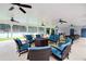 Covered outdoor lounge area with a fire pit, couches, and multiple ceiling fans creating a comfortable gathering space at 2540 Ridgehurst Dr, Buford, GA 30518