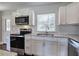 Modern kitchen with stainless steel appliances, white cabinets, granite countertops, and stylish backsplash at 2646 Rockcliff Road Se, Atlanta, GA 30316
