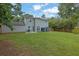 Wide view of grassy backyard featuring patio set, storage shed, and privacy fence at 5515 Pennybrook Trl, Stone Mountain, GA 30087