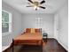 Modern bedroom with an accent wall of decorative prints, bed, and a ceiling fan at 5515 Pennybrook Trl, Stone Mountain, GA 30087