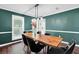 Dining room with wooden table, seating, contemporary lighting, and painted green walls at 5515 Pennybrook Trl, Stone Mountain, GA 30087
