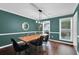 Dining room with wooden table, black chairs, modern lighting, and dark wood floors at 5515 Pennybrook Trl, Stone Mountain, GA 30087