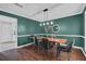 Open concept dining room featuring a wood table, dark green walls, and modern lighting at 5515 Pennybrook Trl, Stone Mountain, GA 30087