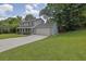Two-story home with a well-manicured lawn, long driveway, and attached two-car garage at 5515 Pennybrook Trl, Stone Mountain, GA 30087