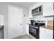 Well-lit kitchen with granite countertops, white cabinets, and stainless steel oven and microwave at 5515 Pennybrook Trl, Stone Mountain, GA 30087