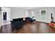 Bright living area with hardwood floors, a dark sofa, and natural light from the windows at 5515 Pennybrook Trl, Stone Mountain, GA 30087