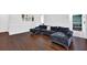 Open living space showcasing hardwood floors, a modern sofa, and views into the dining room at 5515 Pennybrook Trl, Stone Mountain, GA 30087