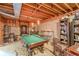 Spacious basement with exposed ceiling, featuring a pool table, bar stools, and ample shelving for storage at 1101 Parkland Se Run, Smyrna, GA 30082