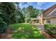 Beautiful backyard featuring a covered deck, stone patio, lush green lawn, and mature trees at 1324 Concord Sw Cir, Lilburn, GA 30047