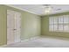 Bedroom with neutral carpet, sage green walls, white trim, ceiling fan, and shuttered window at 1324 Concord Sw Cir, Lilburn, GA 30047