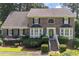 Charming two-story brick home featuring manicured landscaping and a welcoming front entrance with bay windows at 1324 Concord Sw Cir, Lilburn, GA 30047