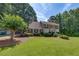 Beautifully landscaped front yard with mature trees, lush green lawn, and a classic two-story home at 1324 Concord Sw Cir, Lilburn, GA 30047