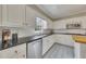 Updated kitchen features white cabinets, a tile backsplash, granite countertops, and modern appliances at 1324 Concord Sw Cir, Lilburn, GA 30047