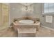 Elegant main bathroom with jacuzzi tub, tile surround, and natural light at 1324 Concord Sw Cir, Lilburn, GA 30047