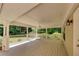 Covered porch with white columns, ceiling fan, wood floor, and view of landscaped backyard at 1324 Concord Sw Cir, Lilburn, GA 30047