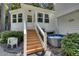 Quaint white home with stairs leading to the entrance and a relaxing hot tub, surrounded by lush greenery at 2716 Meadow Ridge Nw Dr, Duluth, GA 30096
