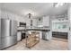Well-lit kitchen features white cabinets, stainless steel appliances, and a view into another living area at 2716 Meadow Ridge Nw Dr, Duluth, GA 30096