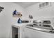 Bright laundry room features modern washer and dryer with overhead shelving and ample storage space at 2716 Meadow Ridge Nw Dr, Duluth, GA 30096
