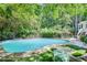 Beautifully maintained backyard pool surrounded by lush trees and comfortable lounge furniture, creating a private oasis at 2716 Meadow Ridge Nw Dr, Duluth, GA 30096